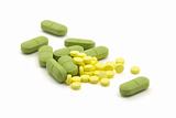 Green and yellow pills with dose on white background