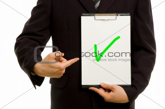 Green tick on clipboard in the hand of a businessman