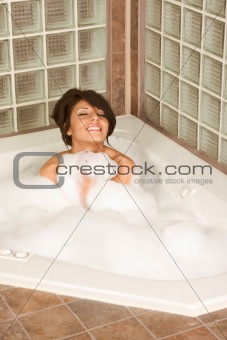 Female relaxing in foam bath