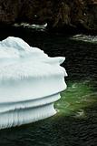 Iceberg outlined against the shoreline,