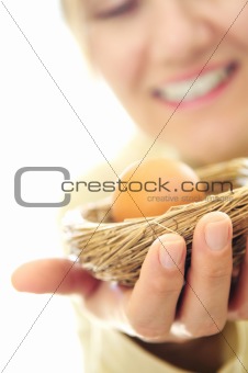 Mature woman holding a nest with an egg