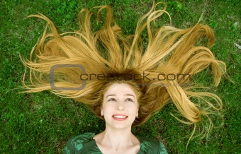 Girl with beautiful hair laying in the grass