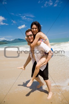 hunk carrying woman piggyback style ath beach
