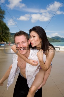 happy playful couple at the beach 