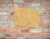 Sheet paper, hanging on a brick wall