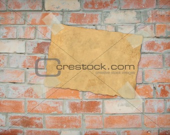 Sheet paper, hanging on a brick wall