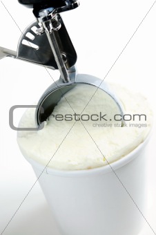 Tub of vanilla ice cream with a scoop