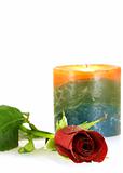single red rose with droplets and burning candle