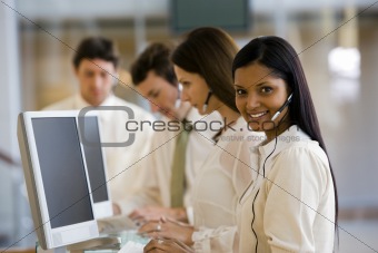 Business woman with head set at a computer