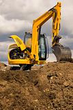 Excavator standing on soil with open engine