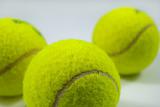 tennis balls on gray with shadows
