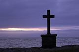 Stone cross in front of the sea