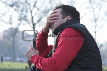 Anxious Man Holding a Mobile Phone