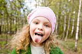 Cheerful girl puts out the tongue