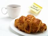 Croissant, cup of coffee and yellow note