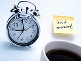 Alarm clock, cup of coffee and yellow note