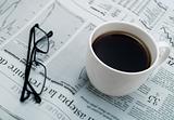 Cup of coffee, glasses and newspaper