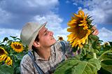 farmer in sunflower field with clouds