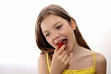 Young girls eats strawberry