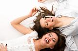 Two smiling businesswomen have fun lying on the floor