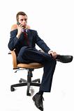 Businessman sitting on an armchair with cell phone.