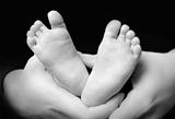 Mother's hands holdning hers son's feet 