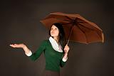 Girl with umbrella checking for rain 