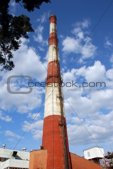 Old factory metallic  funnel on a background sky with clouds