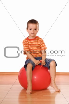 Serious boy with gymnastic ball