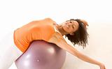 Tanned woman stretching on ball