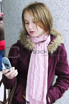 Teenage girl text messaging on cell phone
