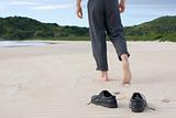 Businessman barefoot on beach