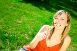 beautiful white woman with sugar candy smiling on a green grass