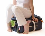 Woman sitting on a suitcase isolated over white