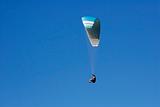 Paraglider on a blue sky.