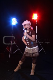 cute girl singing with colorful stage lights