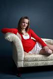 pretty teen in red sweater sitting on couch