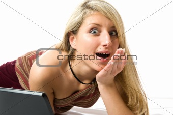 Surprised. Beautiful girl with blonde hair using a laptop computer.