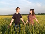 Young Couple Walking Field Holding Hands
