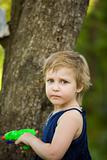 Little girl plays near a tree