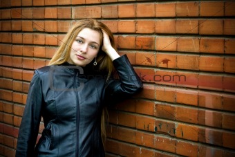 Beautiful girl standing in front of old brick wall