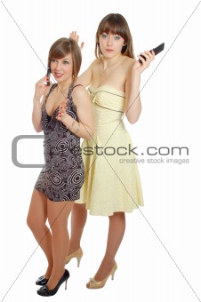 Two young beautiful girls speak by mobile