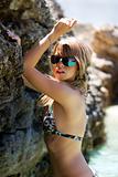 Sexy girl in bikini posing with sea rocks