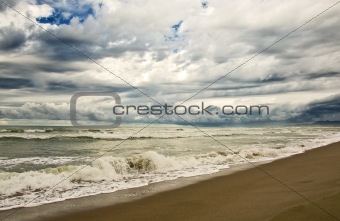 empty beach diring a storm with heavy clouds
