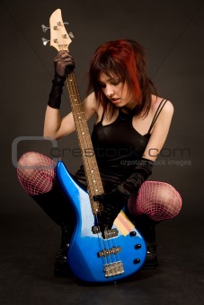 Attractive girl looking at bass guitar