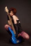 Attractive girl holding bass guitar
