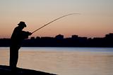 Fisherman fishing in the sun set