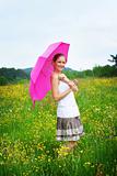 happy woman on a meadow with an umbrella