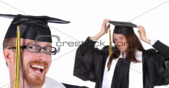 two successful student in graduation gowns 
