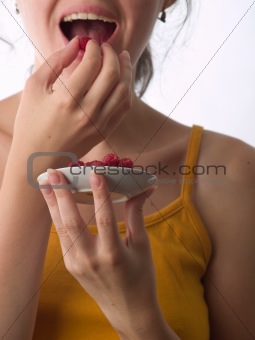 Girl eating raspberry